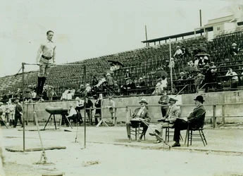 Athlete on a High Bar with Judges